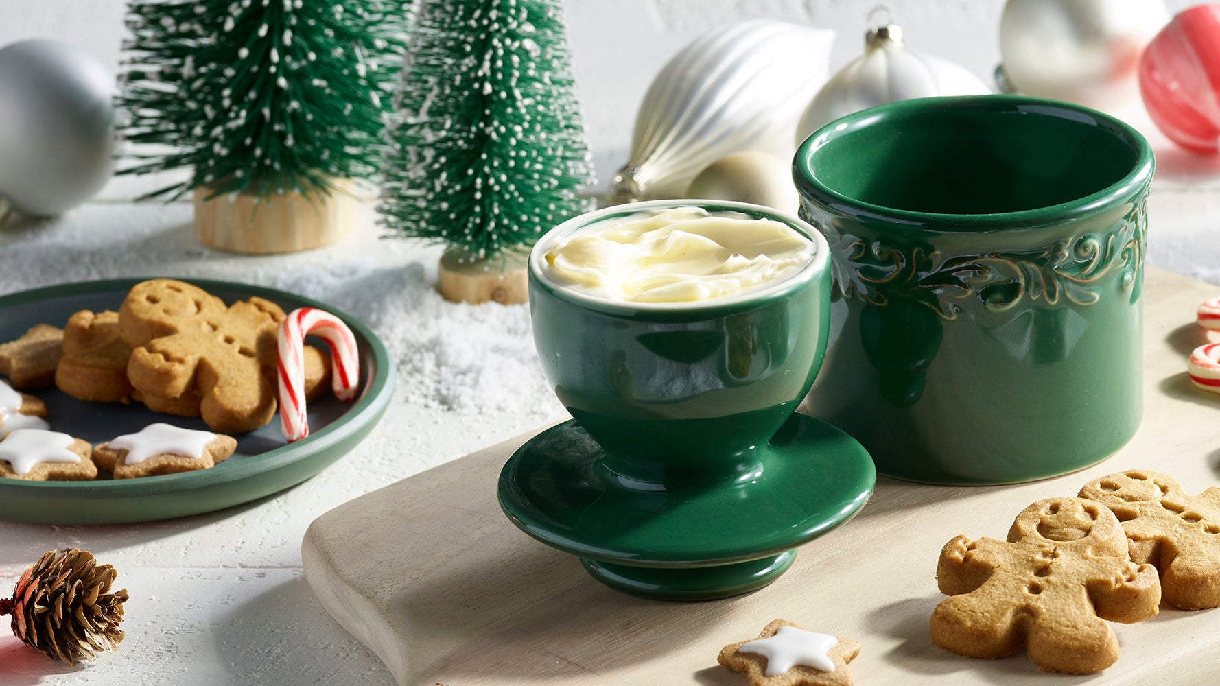 butter bell crock and cookies on a festive table with Christmas decorations.
